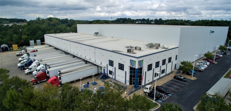 Exterior view of Lineage’s College Park cold storage facility in Atlanta, showcasing a modern warehouse design with multiple loading docks and ample truck parking.