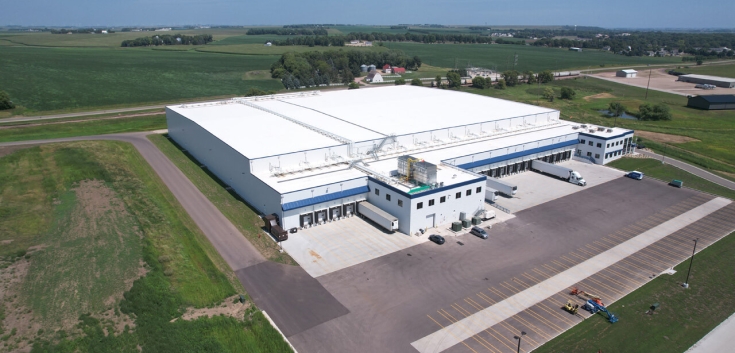 Aerial view of Lineage's Luverne cold storage warehouse in Minnesota, featuring multiple loading docks, parked trailers, and expansive surrounding farmland, highlighting its strategic location for cold chain operations.