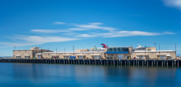 Wide-angle view of Lineage Seattle-Garfield facility along the waterfront under a clear blue sky, showcasing port operations and facilities.