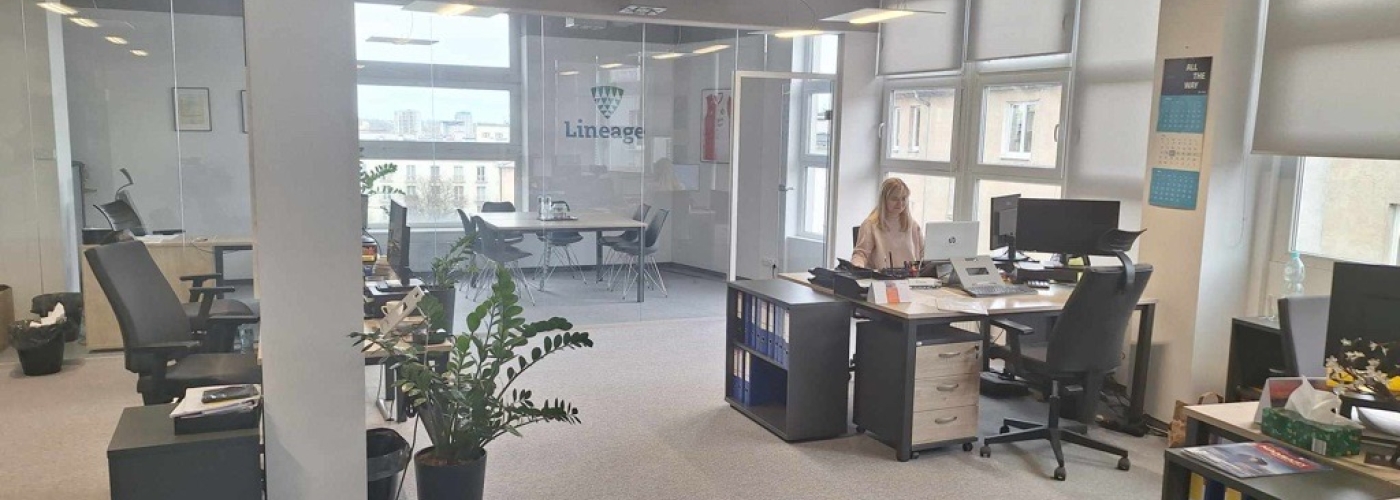 Modern Lineage office space in Gdynia, Poland, featuring an open workspace with desks, computers, and a glass-walled conference room, supporting freight forwarding and logistics operations.
