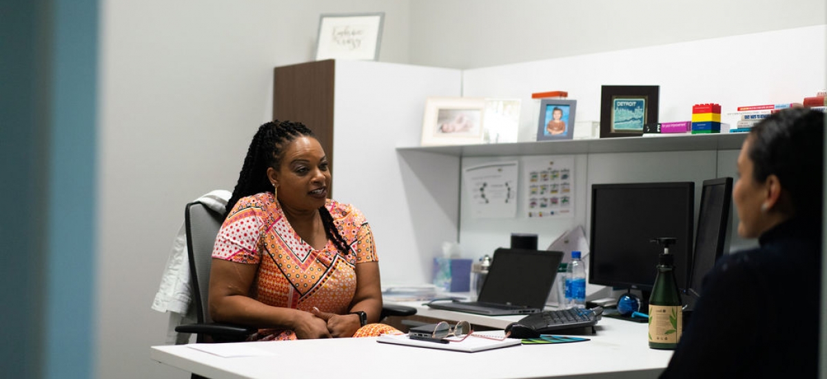 Angie talking to a coworker in an office