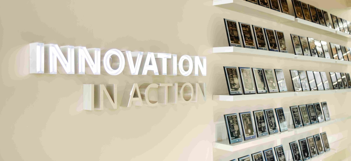 A wall inside Lineage's Novi HQ displays plaques of patents issued on white shelves alongside a three dimensional sign that reads "Innovation In Action"