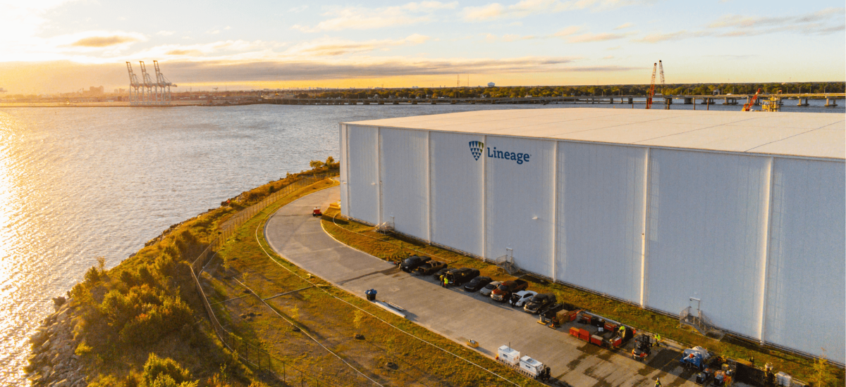 Lineage's Portsmouth, VA facility located near the waterfront with a view of the port and several cranes in the background.