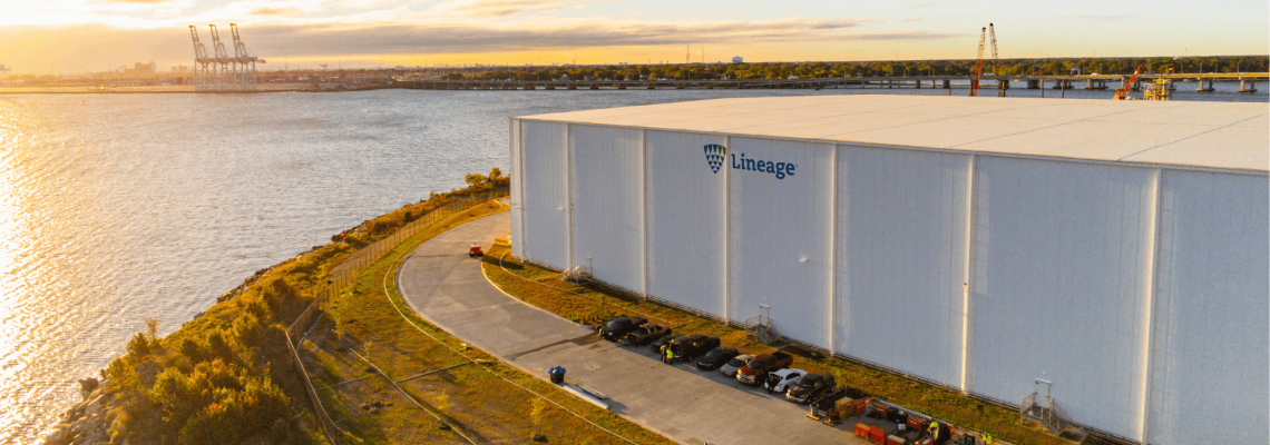 Lineage's Portsmouth, VA facility located near the waterfront with a view of the port and several cranes in the background.