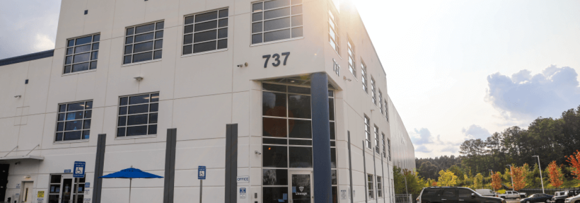 Exterior of a Lineage Logistics cold storage facility in Atlanta, Georgia, showcasing modern architecture and accessibility under a bright afternoon sun.