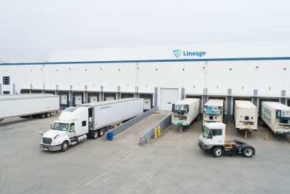 Tractor trailers parked at the dock of a Lineage refrigerated warehouse