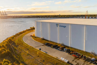 Lineage's Portsmouth, VA facility located near the waterfront with a view of the port and several cranes in the background.