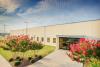 Photo of main entrance to Decatur, AL facility with flowers in bloom