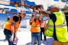 Workers wearing safety gear inspect pipes at a Lineage cold storage facility.