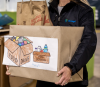 Person in Lineage jacket holding box of food for donation