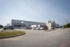 Exterior view of Lineage’s Macon cold storage facility in Atlanta, Georgia, featuring a white warehouse with loading docks, fenced perimeter and a small office area.