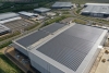 Lineage’s Peterborough cold storage facility with solar panels, loading bays, and branded trucks.